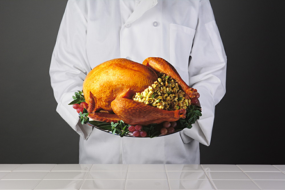 turkeypageA chef holding a platter with a Thanksgiving Turkey with all the trimmings